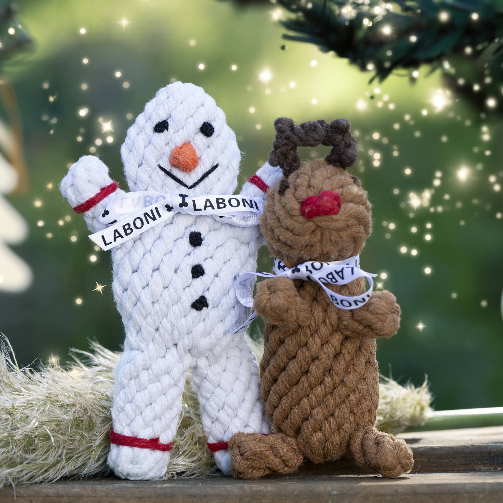 Jouets en corde Laboni posés ensemble : Shawn le Bonhomme de Neige et Rudi le Renne sur fond hivernal lumineux.